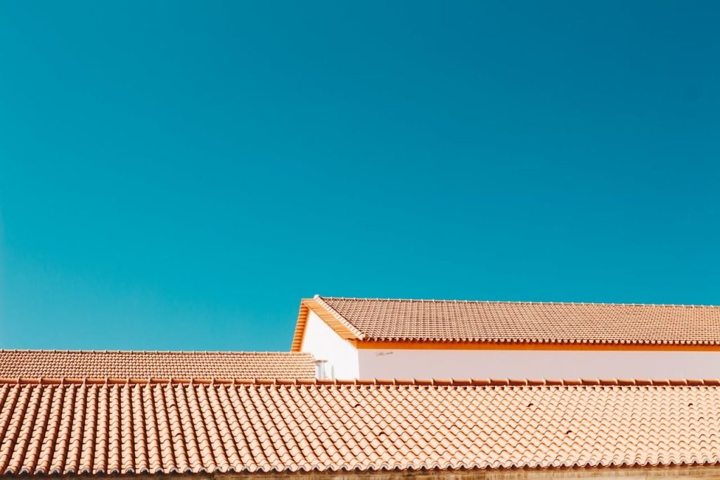 A serene image of terracotta roofs contrasting with a vibrant blue sky, showcasing architectural simplicity.